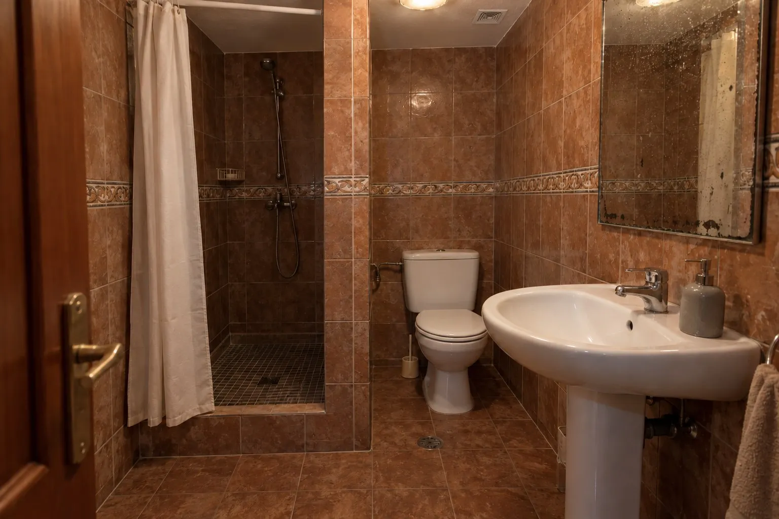 Baño con azulejo marrón y cortina de ducha en un piso de Torreblanca, Fuengirola, antes de la reforma